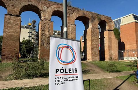 Lo stendardo di Póleis – Polo dell'Esquilino per l'Innovazione Sociale davanti ad antichi archi in mattoni